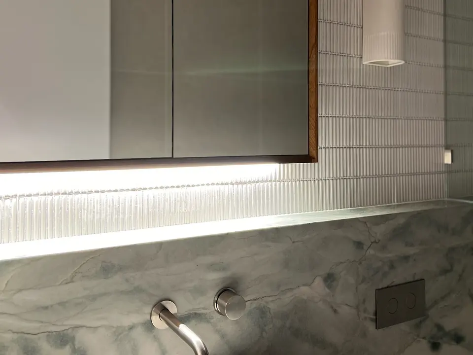 Bathroom with backlit mirror and smart lighting