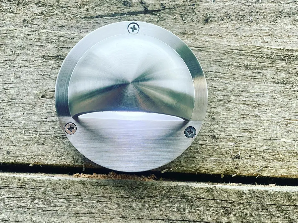 Stainless step light in a timber deck